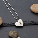 Silver necklace with a heart pendant featuring a paw print