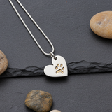 Silver necklace with a heart pendant featuring a paw print