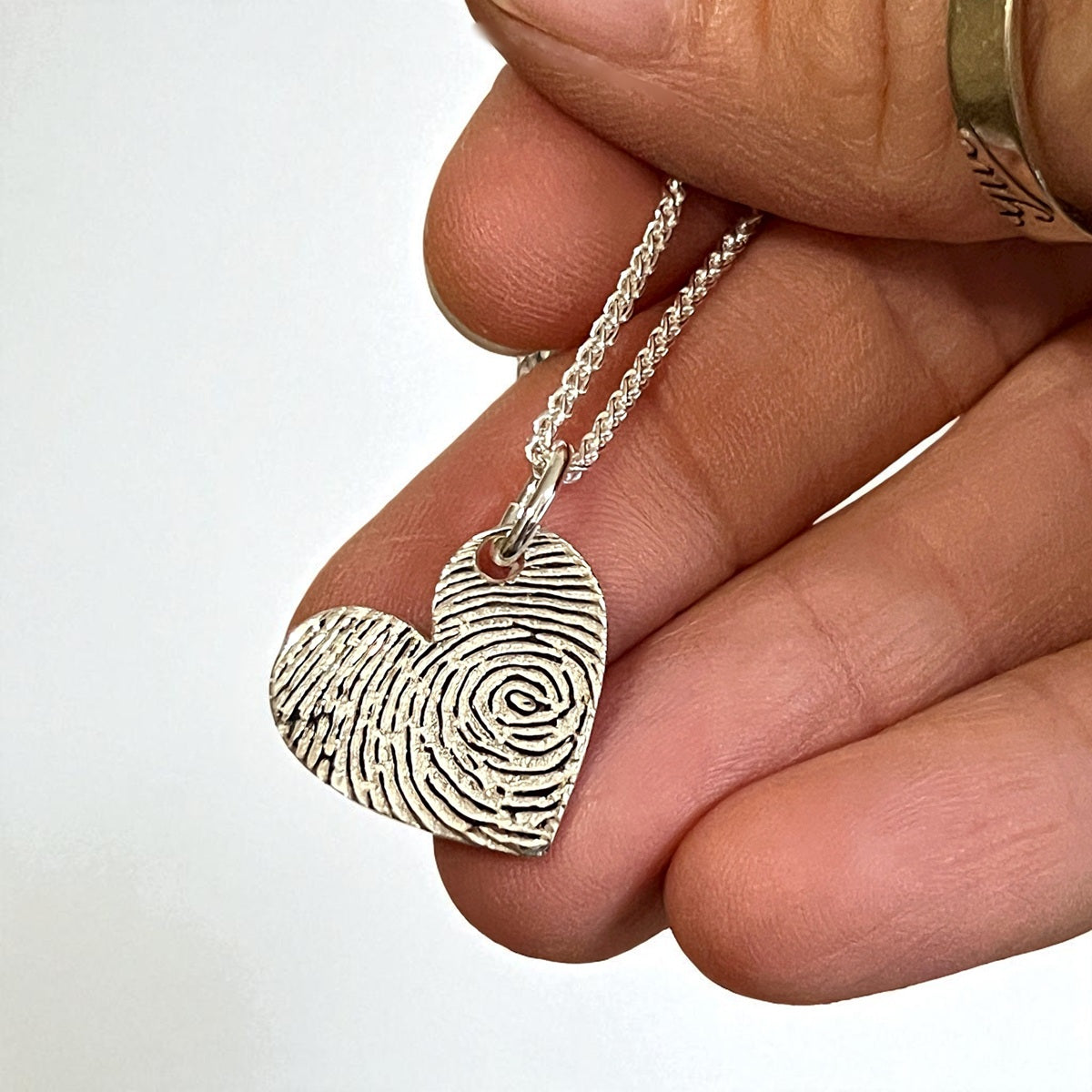 Heart-shaped fingerprint pendant on a chain