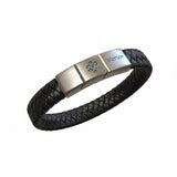 Memorial ashes captured in a pawprint on a braided black leather bracelet