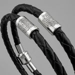 Black braided leather bracelet with silver fingerprint accent caps and a matching silver magnetic clasp.