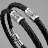 Black braided leather bracelet with silver fingerprint accent caps and a matching silver magnetic clasp.