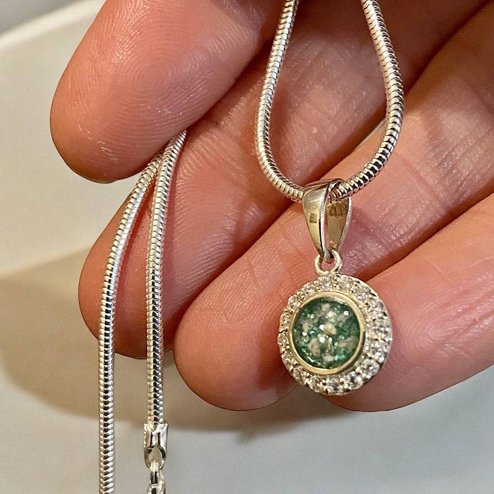 hand holding a memorial ashes circle necklace