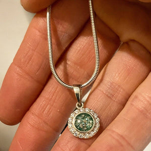 hand holding a memorial ashes circle necklace