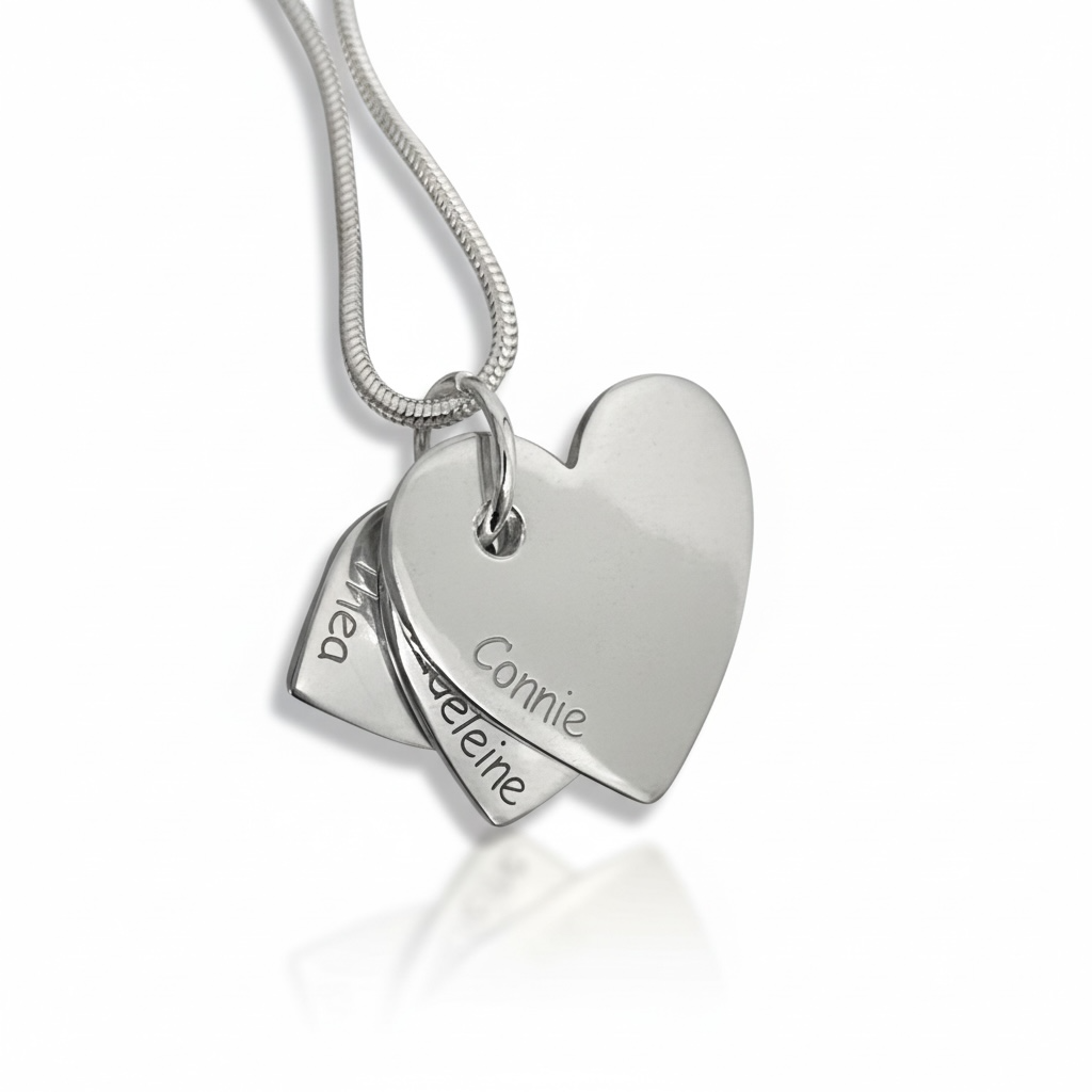 Silver heart-shaped pendant with engraved names on a white background