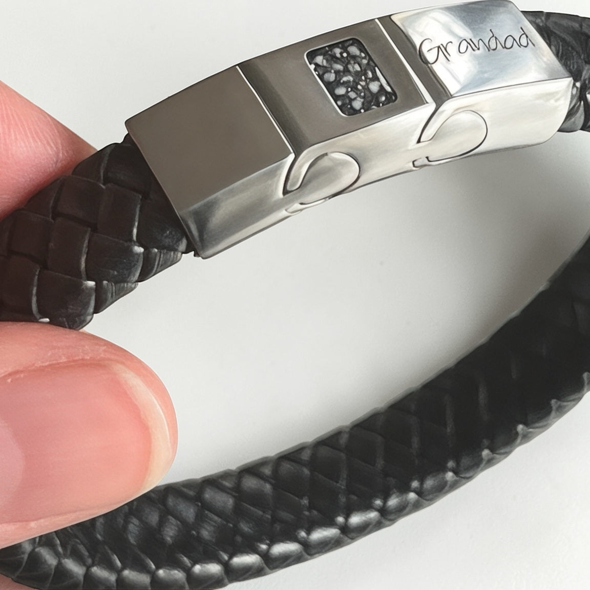Memorial ashes captured on a braided black leather bracelet